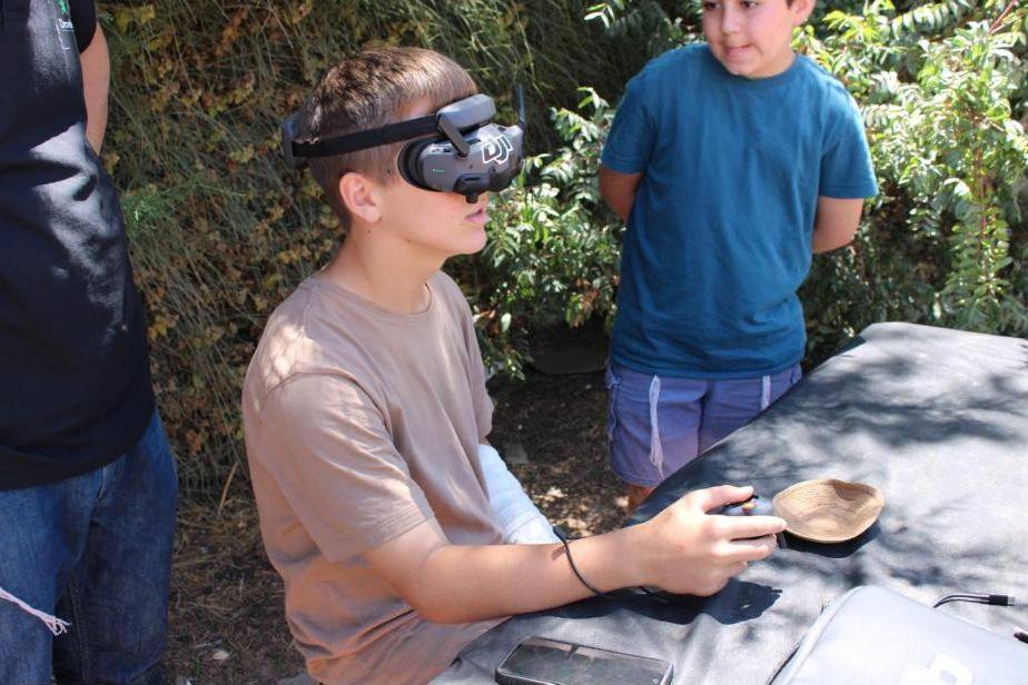 תלמידים מתנסים בהטסת רחפן עם משקפי FPV